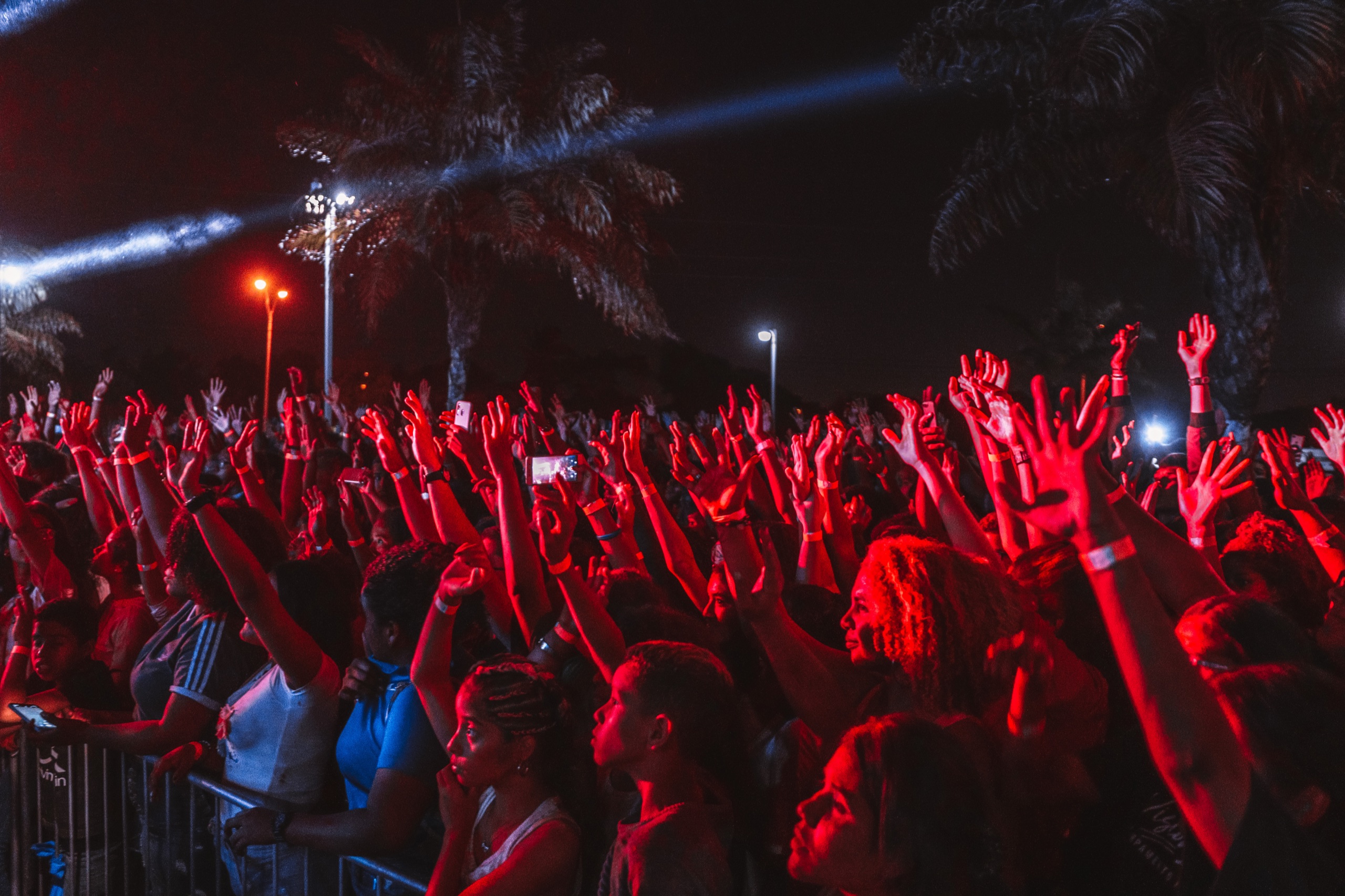A rave crowd dancing together under red and blue stage lights